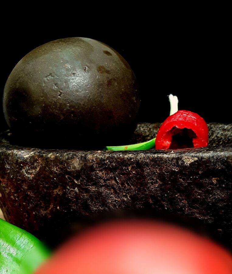 Grinding llajwa ingredients on a Bolivian batán stone